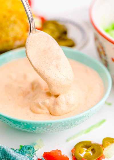 homemade creamy jalapeno sauce on a spoon above a bowl